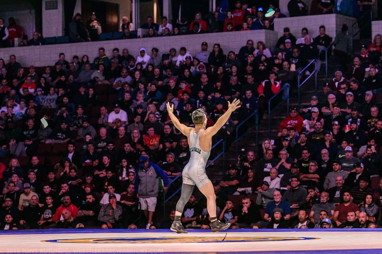 Peyton Omania raising his arms to the crowd after the state final