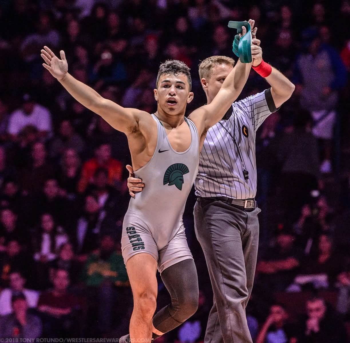 Peyton Omania having his hand raised after winning the state final